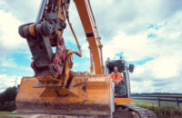 Construction worker on excavator planning the work to be done on the site