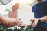 Home delivery service and working service mind, Woman customer hand receiving a cardboard boxes parcel from delivery service courier.