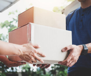 Home delivery service and working service mind, Woman customer hand receiving a cardboard boxes parcel from delivery service courier.