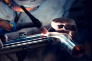TIG welder welds elbow to polished stainless steel pipe