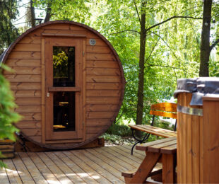 outdoor wooden barrel sauna in the garden